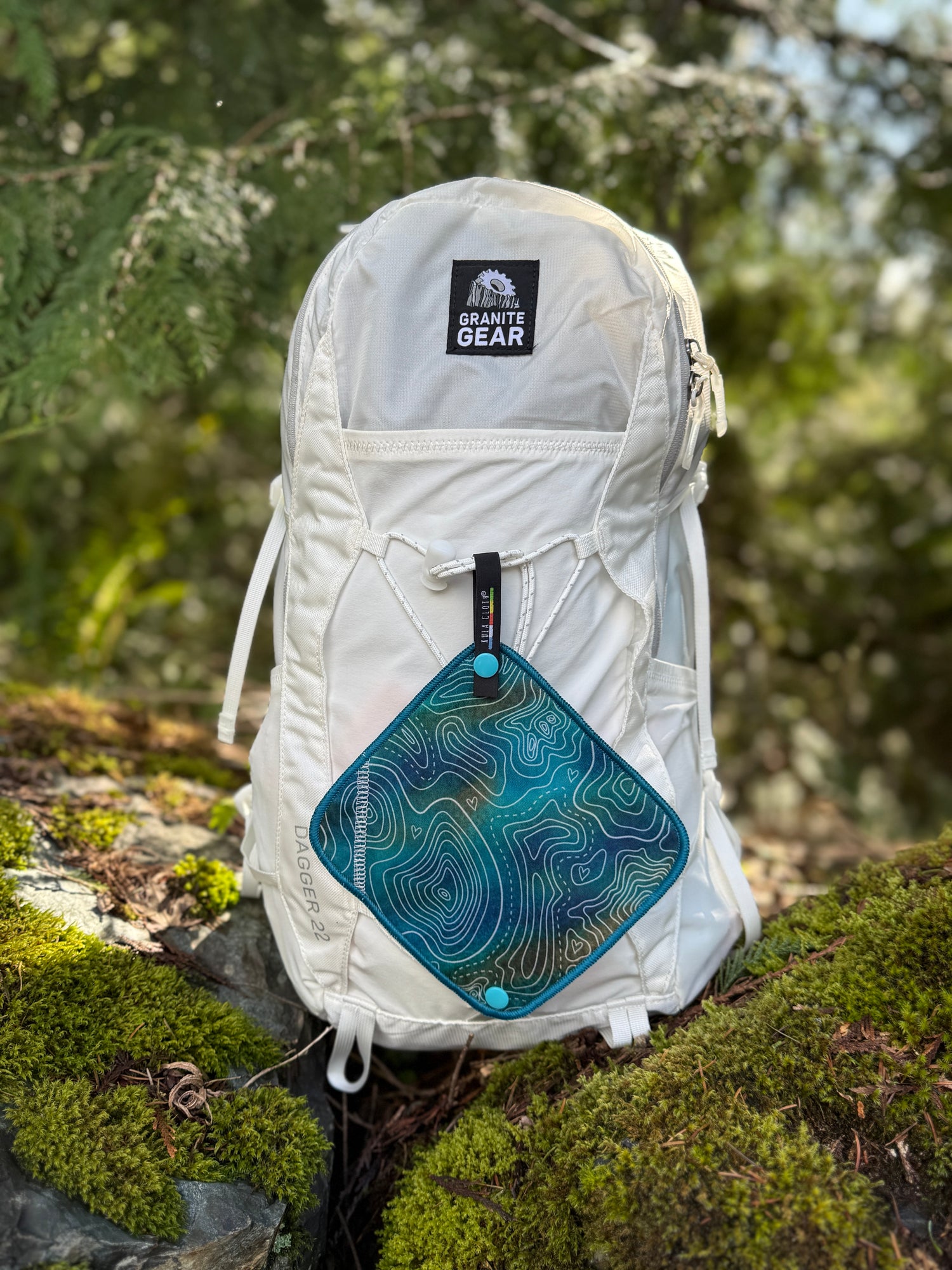 White backpack with a visible brand logo on a natural background
