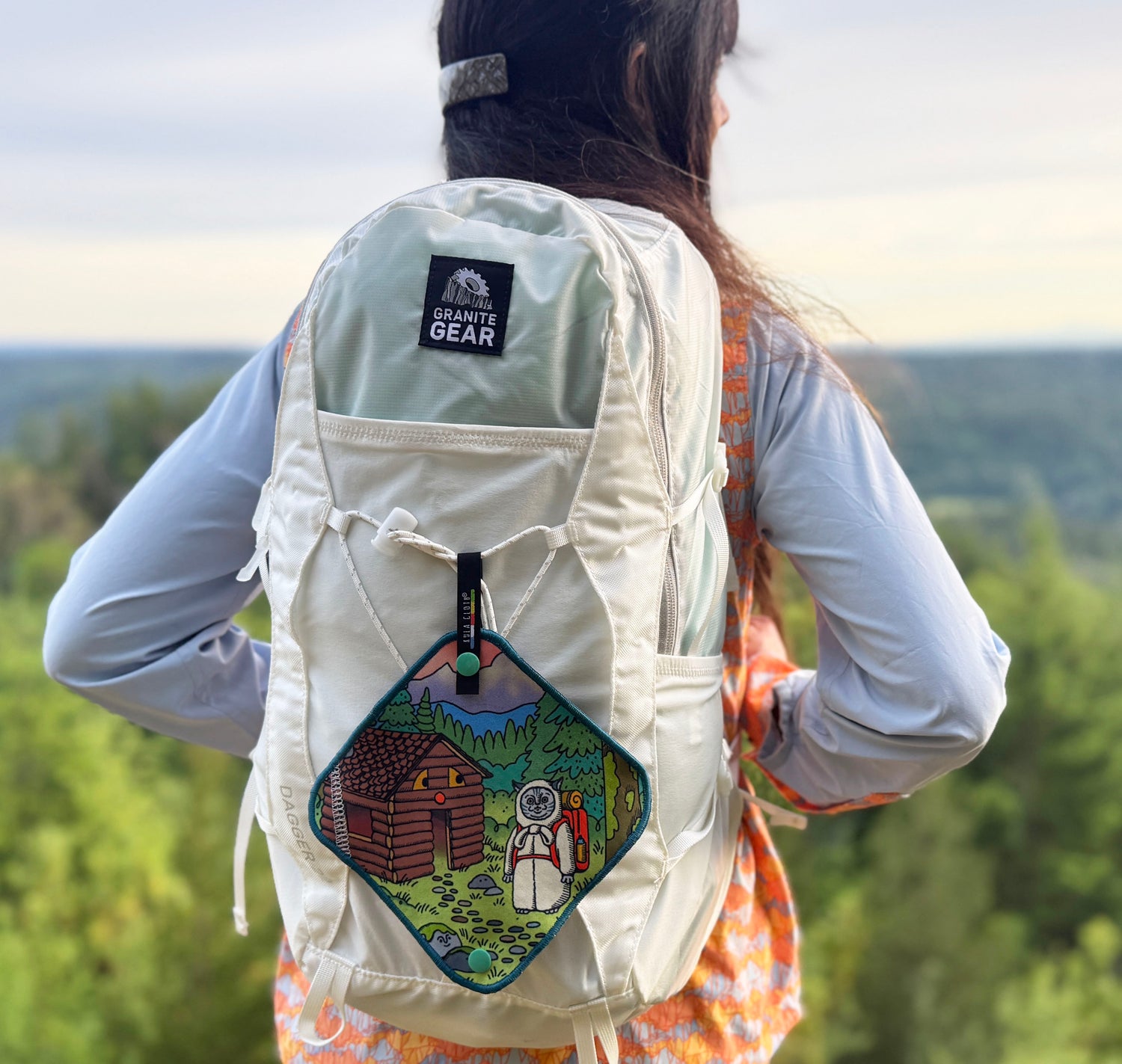 person wearing a white backpack with an antimicrobial pee cloth on backpack