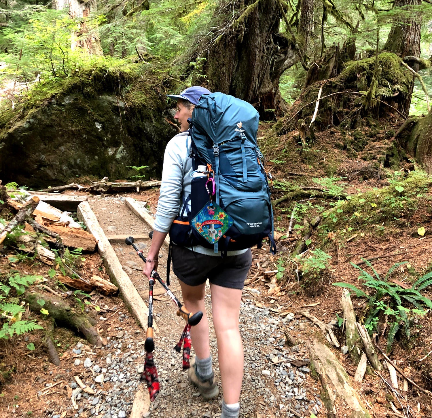 woman hiking in the woods with a pee cloth on her backpack