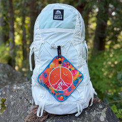 orange antimicrobial pee cloth on a white backpack outdoors