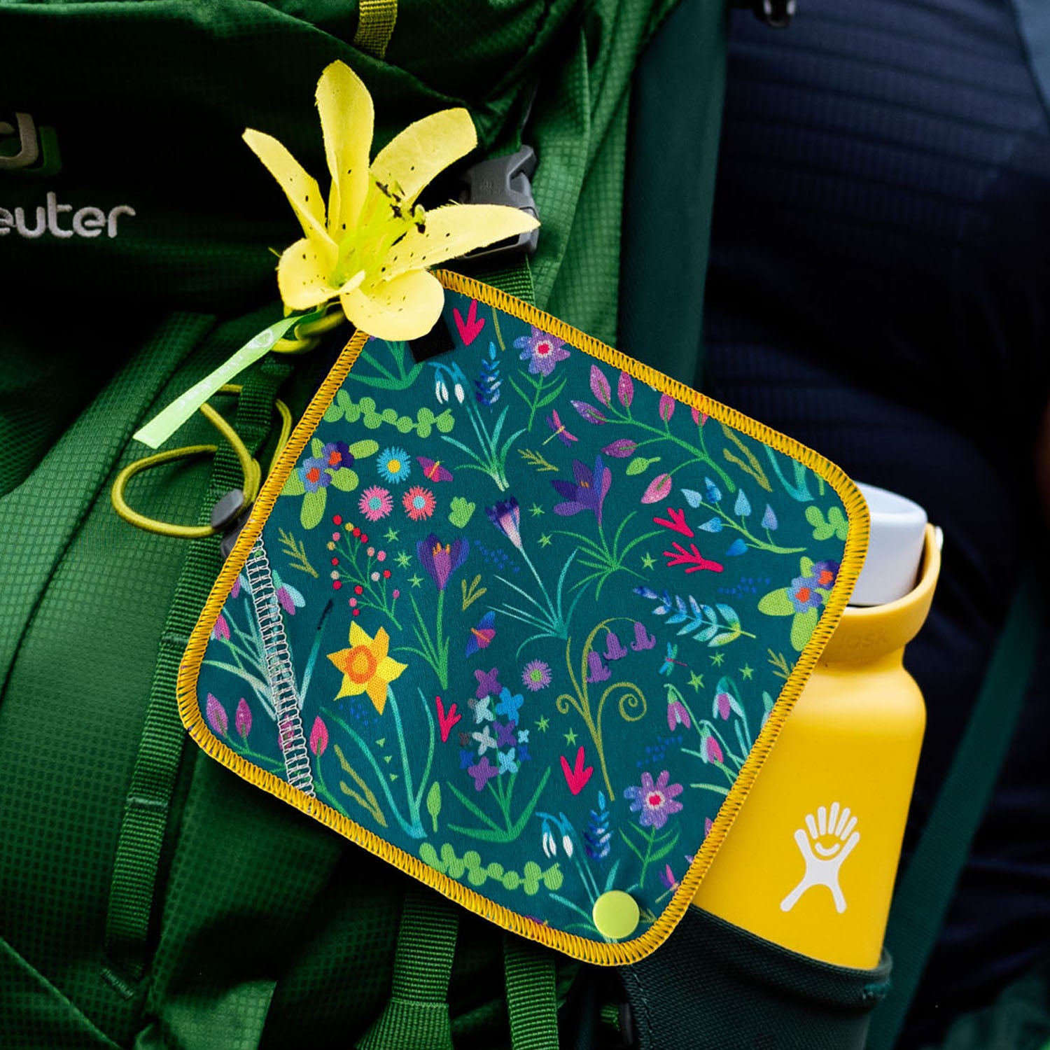 floral green antimicrobial pee cloth on a green backpack
